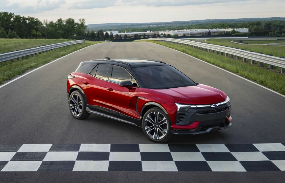 Seven-eighths view of 2024 Chevrolet Blazer EV SS in Radiant Red Tintcoat parked in front of a checkered finish line. Preproduction model shown. Actual production model may vary. 2024 Chevrolet Blazer EV available Spring 2023.